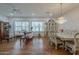 A bright living room showcasing hardwood floors, shuttered windows, and classic sofas with a chandelier above the dining set at 17770 N 66Th Ln, Glendale, AZ 85308