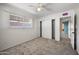 Bedroom showing light walls and flooring, a window, closet doors, and doorway leading to another room at 18212 N 43Rd Pl, Phoenix, AZ 85032