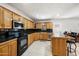 Traditional kitchen featuring wood cabinetry, black countertops, stainless appliances, and a large island at 18212 N 43Rd Pl, Phoenix, AZ 85032