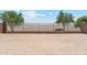 View of the large, flat backyard with desert landscaping and block fence at 18333 N Presley Ln, Maricopa, AZ 85138