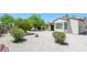 Desert landscaped backyard featuring decorative gravel, shrubs, and covered patio on a sunny day at 18651 N Salerno Ct, Surprise, AZ 85387