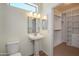 Bathroom featuring a pedestal sink and a doorway to a walk-in closet at 18651 N Salerno Ct, Surprise, AZ 85387