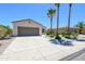 Home featuring two-car garage, desert landscaping, paved drive and sidewalks, with palm trees at 18651 N Salerno Ct, Surprise, AZ 85387