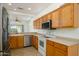 Kitchen with oak cabinets, stainless steel dishwasher, and white appliances at 18651 N Salerno Ct, Surprise, AZ 85387