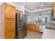 Well-lit kitchen with stainless steel refrigerator and light wood cabinets at 18651 N Salerno Ct, Surprise, AZ 85387