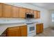 Kitchen features wooden cabinets, white appliances, and light countertops at 18651 N Salerno Ct, Surprise, AZ 85387
