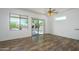 Bright, open living room featuring wood-look floors, neutral walls, and a sliding glass door at 18651 N Salerno Ct, Surprise, AZ 85387