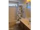 Well-lit bathroom with a shower-tub combo, vanity sink, and playful dinosaur-themed shower curtain at 2125 E Danbury Rd, Phoenix, AZ 85022