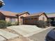 Single-story home boasting a well-kept lawn, mature bushes, and a two car garage at 2125 E Danbury Rd, Phoenix, AZ 85022