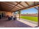 Spacious backyard featuring a covered patio, artificial turf, and a storage shed for convenience at 215 S 132Nd St, Chandler, AZ 85225