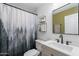 Stylish bathroom features modern fixtures, a new vanity, decorative shelving, and a forest themed shower curtain at 215 S 132Nd St, Chandler, AZ 85225