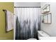 Bathroom features new vanity, greenery on shelves, forest shower curtain, and a towel on the hardware at 215 S 132Nd St, Chandler, AZ 85225