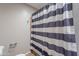 Close-up of shower with new tiling and dark blue and white striped curtain at 215 S 132Nd St, Chandler, AZ 85225
