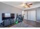 Bedroom features hardwood floors, a ceiling fan, and a dresser with mounted TV at 215 S 132Nd St, Chandler, AZ 85225
