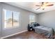 Comfortable bedroom featuring hardwood floors, two large windows, ceiling fan, and neutral gray wall paint at 215 S 132Nd St, Chandler, AZ 85225