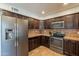 Bright kitchen with stainless steel refrigerator, dark wood cabinets, and modern appliances at 215 S 132Nd St, Chandler, AZ 85225