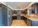 Spacious kitchen with stainless steel appliances, dark wood cabinets, and tile floors at 215 S 132Nd St, Chandler, AZ 85225