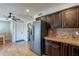 Open kitchen with stainless steel fridge, dark cabinets, and view to dining area at 215 S 132Nd St, Chandler, AZ 85225