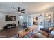 Spacious living room with hardwood floors, ceiling fan, TV, and an open view into the kitchen at 215 S 132Nd St, Chandler, AZ 85225