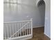 A view of the hallway's archway from the top of the stairs, accented by white railings at 2367 E Huntington Dr, Phoenix, AZ 85040