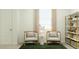 Cozy sitting area with comfortable chairs, natural light, and a stylish bookshelf for relaxation at 24647 N 164Th Dr, Surprise, AZ 85387