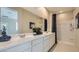 Bright bathroom featuring double sinks and shower with large vanity mirror at 24962 N 174Th Ave, Surprise, AZ 85387