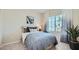 This cozy bedroom is enhanced with a cool color scheme, art, and natural light from the bright window at 24962 N 174Th Ave, Surprise, AZ 85387