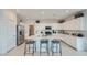 Bright modern kitchen boasts white cabinets, stainless appliances, and island seating at 24962 N 174Th Ave, Surprise, AZ 85387