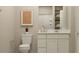 Bathroom with a white vanity, coordinated art, toilet, framed mirror and well-organized storage, with a neutral palette at 25004 N 174Th Ave, Surprise, AZ 85387