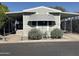 Charming mobile home featuring carport, awning, and well-maintained landscaping at 300 S Val Vista Dr # 54, Mesa, AZ 85204