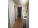 Well-lit hallway with wood flooring, leading to a bedroom and laundry area at 300 S Val Vista Dr # 54, Mesa, AZ 85204