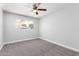 Clean bedroom with carpet, ceiling fan, and window offers a serene, comfortable retreat at 3126 W Stella Ln, Phoenix, AZ 85017