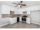 Modern kitchen featuring white cabinets, stainless steel appliances, and decorative backsplash at 3126 W Stella Ln, Phoenix, AZ 85017