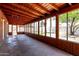 Enclosed back patio with wood paneled walls and ceiling beams and multiple windows to backyard at 3126 W Stella Ln, Phoenix, AZ 85017