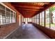 Enclosed back patio with wood paneled walls and ceiling beams and multiple windows to backyard at 3126 W Stella Ln, Phoenix, AZ 85017