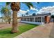 Backyard featuring manicured lawn, palm trees, brick patio, and enclosed sunroom at 3126 W Stella Ln, Phoenix, AZ 85017