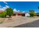 Charming single-story brick home featuring a spacious driveway, mature landscaping, and a well-maintained front yard at 3126 W Stella Ln, Phoenix, AZ 85017