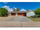 Charming brick home features a spacious driveway, mature trees, and lush landscaping at 3126 W Stella Ln, Phoenix, AZ 85017