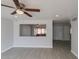 Bright living room featuring wood-look tile flooring, ceiling fan and view of an enclosed patio at 3126 W Stella Ln, Phoenix, AZ 85017