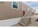 Tan mobile home entrance features modern metal handrails and a red screen door at 320 E Mckellips Rd # 45, Mesa, AZ 85201