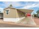 Side exterior angle of tan home featuring a covered carport, window awning, and good curb appeal at 320 E Mckellips Rd # 45, Mesa, AZ 85201