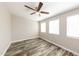 This spacious bedroom features modern floors, a ceiling fan, and plenty of natural light from the windows at 4833 N 63Rd Ln, Phoenix, AZ 85033