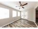 Bright bedroom featuring modern floors, three windows, and a glass door leading to the backyard at 4833 N 63Rd Ln, Phoenix, AZ 85033