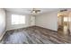 Spacious living room featuring wood flooring, a ceiling fan, and natural light from a large window at 4833 N 63Rd Ln, Phoenix, AZ 85033
