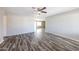 Bright living room showcasing wood flooring, a ceiling fan, and a seamless flow to the kitchen at 4833 N 63Rd Ln, Phoenix, AZ 85033
