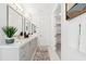 Well-lit bathroom with double vanity, elegant mirrors, and a decorative accent wall at 5250 E Deer Valley Dr # 140, Phoenix, AZ 85054
