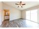 Comfortable bedroom with ceiling fan, adjacent bath, and sliding glass door to outside at 5533 W Sunnyside Dr, Glendale, AZ 85304