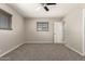 Comfortable bedroom featuring carpet flooring, a ceiling fan, two bright windows, and neutral walls at 6022 E Colby St, Mesa, AZ 85205