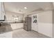 Bright kitchen with white cabinets, stainless steel refrigerator, granite countertops, and tile flooring at 6022 E Colby St, Mesa, AZ 85205