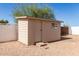 A backyard storage shed with a small window and stoop located in a fenced backyard at 6022 E Colby St, Mesa, AZ 85205